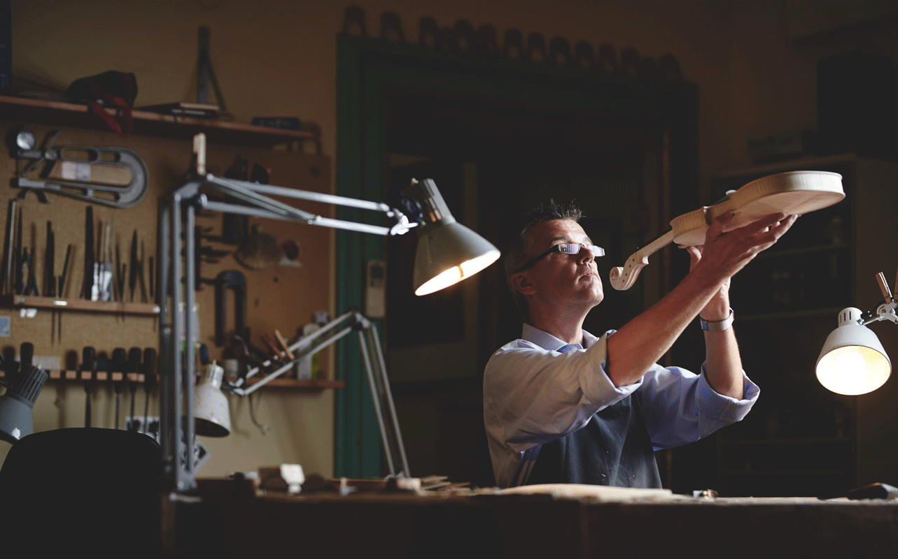 Edgar Russ is working on a violin in his studio. Copyright Koeningshofer